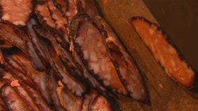 Di sanguinaccio casalingo nella porcellana della campagna, affettante con un coltello fotografia stock Di sanguinaccio casalingo nella porcellana della campagna, affettante con un coltello fotografia stock