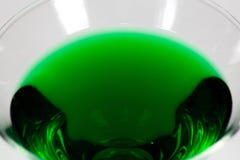 Dia das Bruxas inspirou o cocktail da cor verde em um vidro claro que senta-se em uma tabela branca que espera para ser apreciado foto de stock royalty free Dia das Bruxas inspirou o cocktail da cor verde em um vidro claro que senta-se em uma tabela branca que espera para ser apreciado foto de stock royalty free