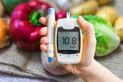 Diabetic diet and diabetes concept. Hand holds glucometer.