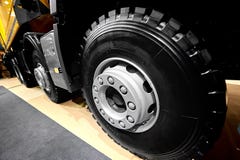 Diagonal view on tipper truck wheels and tires with blured background. Truck wheel rim. Truck chassis exhibit on car Exhibition. C royalty free stock images Diagonal view on tipper truck wheels and tires with blured background. Truck wheel rim. Truck chassis exhibit on car Exhibition. C royalty free stock images