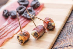 Die gebackenen Trockenpflaumen, die mit Käse und Speck gefüllt wurden, rollten, Snack oder Aperitif lizenzfreies stockbild Die gebackenen Trockenpflaumen, die mit Käse und Speck gefüllt wurden, rollten, Snack oder Aperitif lizenzfreies stockbild