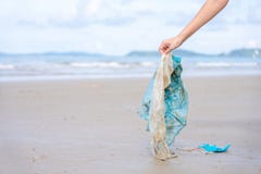 Die Hand der Frau, die aufhebt, benutzte Plastiktasche auf dem Sandstrand und säuberte Küstenstrand Umweltverschmutzung, ökologis stockbild Die Hand der Frau, die aufhebt, benutzte Plastiktasche auf dem Sandstrand und säuberte Küstenstrand Umweltverschmutzung, ökologis stockbild