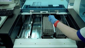 Die Hand der Frau, die Gestelle mit Reagenzgläsern in den Maschinenabschluß oben einsetzt Elektronische Ausrüstung im Labor Masch stock video Die Hand der Frau, die Gestelle mit Reagenzgläsern in den Maschinenabschluß oben einsetzt Elektronische Ausrüstung im Labor Masch stock video