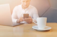 Die Hände des Mannes unter Verwendung des intelligenten Telefons und des Laptops im Innenraum stockbilder Die Hände des Mannes unter Verwendung des intelligenten Telefons und des Laptops im Innenraum stockbilder