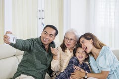 Die nette Familie mit drei Generationen nimmt selfie zu Hause lizenzfreie stockfotos Die nette Familie mit drei Generationen nimmt selfie zu Hause lizenzfreie stockfotos