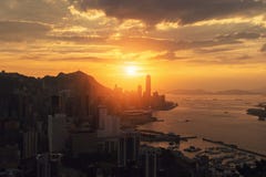 Die Sonne geht bei Hong Kong Downtown und bei Victoria Harbour unter FI lizenzfreie stockfotografie Die Sonne geht bei Hong Kong Downtown und bei Victoria Harbour unter FI lizenzfreie stockfotografie