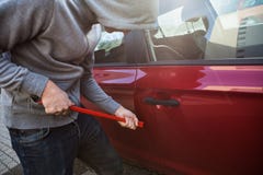 Dieb Opening Cars Tür mit Brechstange lizenzfreie stockfotos Dieb Opening Cars Tür mit Brechstange lizenzfreie stockfotos