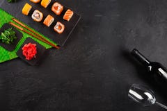 Dienden de sushi Vastgestelde sashimi en de sushibroodjes, de fles wijn en een glas op steenlei stock fotografie Dienden de sushi Vastgestelde sashimi en de sushibroodjes, de fles wijn en een glas op steenlei stock fotografie