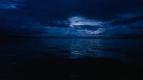 Dieses Foto von einem tiefen blauen mondbeschienen Ozean nachts mit ruhigen Wellen stockbilder Dieses Foto von einem tiefen blauen mondbeschienen Ozean nachts mit ruhigen Wellen stockbilder