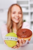 Diet choices of a young girl - apple or doughnut Stock Photos Diet choices of a young girl - apple or doughnut Stock Photos