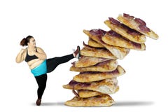 Fat woman kicking pile of pizza royalty free stock photography Fat woman kicking pile of pizza royalty free stock photography