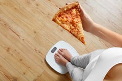 Diet, Fast Food. Woman On Scale Holding Pizza. Obesity. royalty free stock photos Diet, Fast Food. Woman On Scale Holding Pizza. Obesity. royalty free stock photos