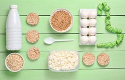 Diet, Healthy Food. Bottle Of Yogurt, Crispy Round Bread, Buckwheat Noodles, Oatmeal, Cottage Cheese, Egg Tray On A Blue Wooden B Royalty Free Stock Photo
