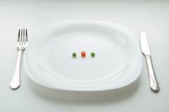 diet-snack-big-plate-three-small-pieces-vegetables-white-empty-fork-view-side-92902513.jpg
