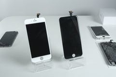 Different modern mobile phones with broken screen on white table royalty free stock photography Different modern mobile phones with broken screen on white table royalty free stock photography