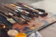 Different size paintbrush collection on an old palette with oil paint colors blend and a gouache set royalty free stock image Different size paintbrush collection on an old palette with oil paint colors blend and a gouache set royalty free stock image