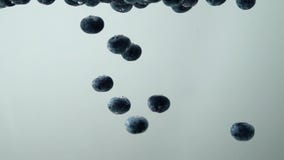 Different tasty fruits fall into the water in slow motion with white background. Blueberries with strawberry. stock video footage Different tasty fruits fall into the water in slow motion with white background. Blueberries with strawberry. stock video footage