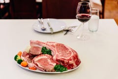 Different types of raw beef with fresh herbs and vegetables on the table for customer selection Stock Photos Different types of raw beef with fresh herbs and vegetables on the table for customer selection Stock Photos