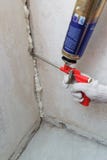 Difficulté de la main du travailleur un loyer dans le mur utilisant la mousse de polyuréthane image libre de droits Difficulté de la main du travailleur un loyer dans le mur utilisant la mousse de polyuréthane image libre de droits