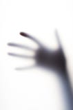 Diffused shadow of hand with thin fingers behind the frosted glass Stock Photography Diffused shadow of hand with thin fingers behind the frosted glass Stock Photography