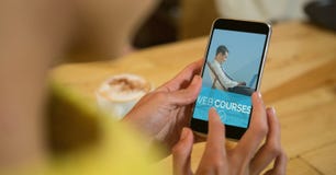 Woman using a phone with e-learning information in the screen royalty free stock photography Woman using a phone with e-learning information in the screen royalty free stock photography