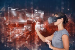 Digital sammansatt bild av den rörande futuristiska skärmen för kvinna, medan genom att använda VR-exponeringsglas Royaltyfri Fotografi Digital sammansatt bild av den rörande futuristiska skärmen för kvinna, medan genom att använda VR-exponeringsglas Royaltyfri Fotografi