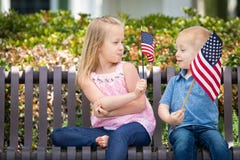 Dimensione competitiva di Comparing American Flag del fratello e della sorella fotografia stock Dimensione competitiva di Comparing American Flag del fratello e della sorella fotografia stock