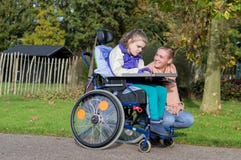 A disabled girl in a wheelchair outside with a care assistant royalty free stock photos A disabled girl in a wheelchair outside with a care assistant royalty free stock photos