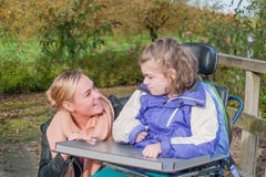 Disabled girl in a wheelchair relaxing outside royalty free stock photography Disabled girl in a wheelchair relaxing outside royalty free stock photography