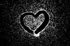 Disegno di simbolo del cuore di amore dal dito sulla polvere bianca del sale sul fondo nero del bordo fotografie stock libere da diritti Disegno di simbolo del cuore di amore dal dito sulla polvere bianca del sale sul fondo nero del bordo fotografie stock libere da diritti