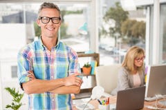 Diseñador casual sonriente delante de su colega de trabajo imágenes de archivo libres de regalías Diseñador casual sonriente delante de su colega de trabajo imágenes de archivo libres de regalías