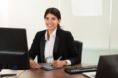 Diseñador de sexo femenino con la tableta gráfica en el escritorio imagen de archivo Diseñador de sexo femenino con la tableta gráfica en el escritorio imagen de archivo
