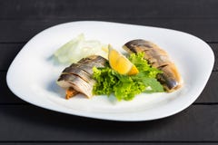 Dish of slices herring fish with greens, lemon and onion