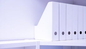 Dispositivi di piegatura dell'ufficio per i documenti Una cartella con gli archivi sulla credenza in un ufficio, in un archivio e immagine stock libera da diritti Dispositivi di piegatura dell'ufficio per i documenti Una cartella con gli archivi sulla credenza in un ufficio, in un archivio e immagine stock libera da diritti
