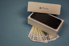 Dispositivi e dollari di iPhone di Apple su un fondo monofonico blu Vorone?, Russia - 3 maggio 2019 immagini stock Dispositivi e dollari di iPhone di Apple su un fondo monofonico blu Vorone?, Russia - 3 maggio 2019 immagini stock