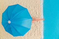 Disposizione piana della bambola sulla spiaggia accanto al concetto astratto di estate del parasole e dell'oceano Immagini Stock Disposizione piana della bambola sulla spiaggia accanto al concetto astratto di estate del parasole e dell'oceano Immagini Stock
