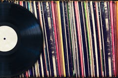 Disque vinyle avec l'espace de copie devant une collection d'albums (titres factices) photo libre de droits Disque vinyle avec l'espace de copie devant une collection d'albums (titres factices) photo libre de droits