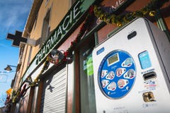 Distributore commerciale del preservativo davanti ad una farmacia nel centro urbano immagine stock Distributore commerciale del preservativo davanti ad una farmacia nel centro urbano immagine stock