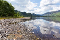 Distrito británico del lago en Cumbria Reino Unido en el agua de Derwent en verano en un día tranquilo con el cielo azul y las nu imagen de archivo libre de regalías Distrito británico del lago en Cumbria Reino Unido en el agua de Derwent en verano en un día tranquilo con el cielo azul y las nu imagen de archivo libre de regalías
