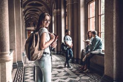 Dit gaat een groot jaar zijn! Glimlachende universitaire student die zich op campus met vrienden op de achtergrond bevinden stock afbeeldingen Dit gaat een groot jaar zijn! Glimlachende universitaire student die zich op campus met vrienden op de achtergrond bevinden stock afbeeldingen