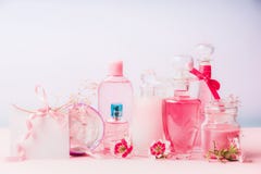 Divers produits cosmétiques naturels dans des bouteilles et des pots avec les fleurs roses au fond en pastel, vue de face Escroqu Images stock Divers produits cosmétiques naturels dans des bouteilles et des pots avec les fleurs roses au fond en pastel, vue de face Escroqu Images stock