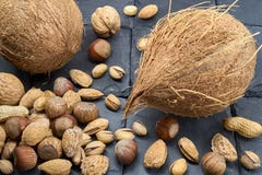 Diversa especie de nueces en una piedra negra de la pizarra Un bocado delicioso foto de archivo Diversa especie de nueces en una piedra negra de la pizarra Un bocado delicioso foto de archivo