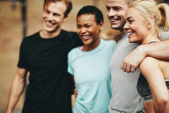 Smiling group of diverse friends standing together in a gym