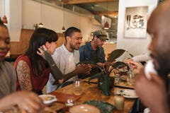 Diverse young friends having fun together over a bistro dinner stock image Diverse young friends having fun together over a bistro dinner stock image
