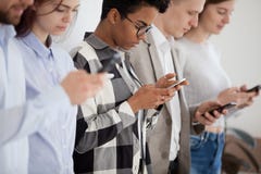 Diverse young people standing in row using smartphones stock image Diverse young people standing in row using smartphones stock image
