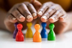 Diversity And Inclusion Concept. Hand Protecting Pawns