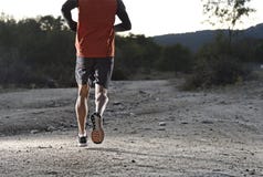 Diviértase al hombre con las piernas atléticas y musculares rasgadas que corren cuesta arriba del camino en entrenamiento del ent fotos de archivo libres de regalías Diviértase al hombre con las piernas atléticas y musculares rasgadas que corren cuesta arriba del camino en entrenamiento del ent fotos de archivo libres de regalías