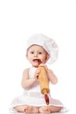 Dix mois de bébé dans un costume du cuisinier étonné et souriant dans la cuisine Petit enfant en tant qu'un petit cuisinier ou sc images stock Dix mois de bébé dans un costume du cuisinier étonné et souriant dans la cuisine Petit enfant en tant qu'un petit cuisinier ou sc images stock