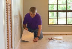 DIY-Hausbesitzermann oder Berufsinstallierungsvinylfliesenbodenbelag Stockbild DIY-Hausbesitzermann oder Berufsinstallierungsvinylfliesenbodenbelag Stockbild