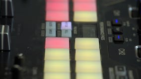 DJ beat maker pushing colourful buttons on the beat pad. Close up of mans fingers pressing buttons at music production studio. DJ beat maker pushing colourful buttons on the beat pad. Close up of mans fingers pressing buttons at music production studio.